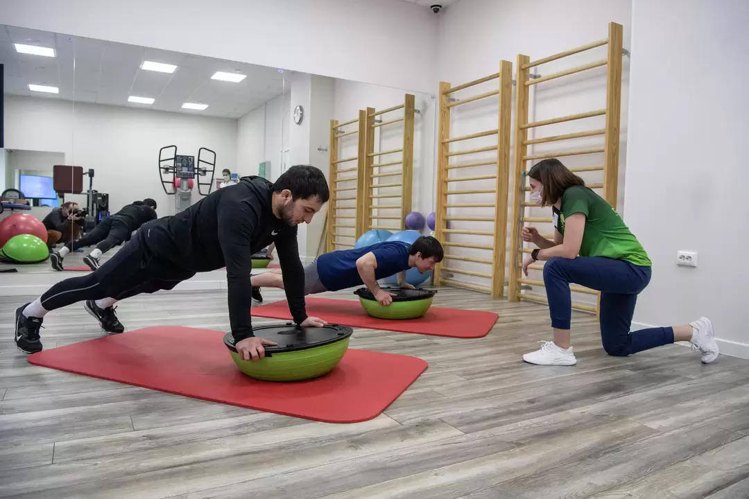 Rehabilitation therapist conducts exercise therapy classes with patients suffering from lower back pain
